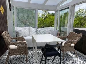 a screened in porch with a white couch and chairs at DIÓFA APARTMAN in Pilismarót