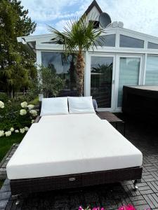 a bed sitting on a patio in front of a house at DIÓFA APARTMAN in Pilismarót