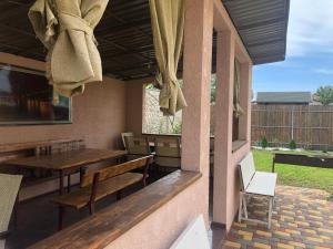 a patio with tables and chairs on a porch at Людмила in Chornomorsk