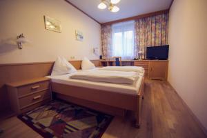 1 dormitorio con 1 cama y TV en Gasthof Bokan en Graz