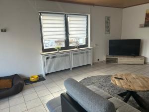 a living room with a couch and a table and a tv at Ferienhaus Windrödel in Herzhausen