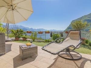 a patio with a chair and an umbrella at EnjoyIseoLake - Blooming Lakefront in Fonteno