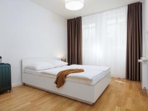 a bedroom with a white bed and a window at smartments Hamburg Aussenalster in Hamburg +25 photos