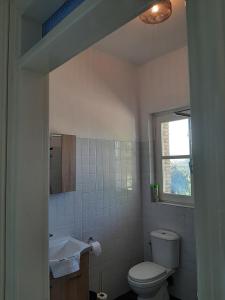 a bathroom with a toilet and a sink and a window at Guesthouse Cato in Vátos +34 photos