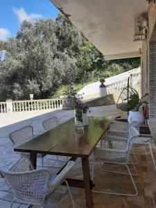 a wooden table and chairs on a patio at Guesthouse Cato in Vátos