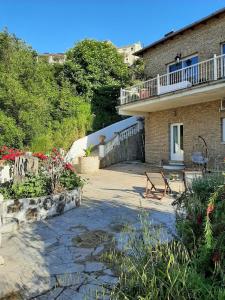 a building with a bench and flowers in front of it at Guesthouse Cato in Vátos