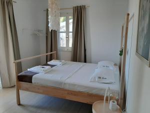 a bedroom with a bed with white sheets and a window at Guesthouse Cato in Vátos