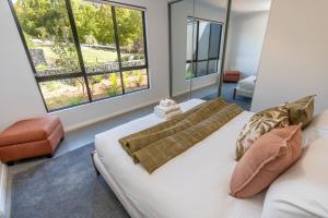 a bedroom with a bed and two large windows at The Valley Lodge in Yallingup +30 photos
