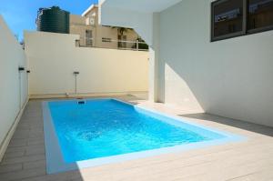a swimming pool on the side of a house at Tropical Escape Flic en Flac in Flic-en-Flac