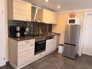 a kitchen with a stainless steel refrigerator and a microwave at Ferienhof Hofmann in Böbrach