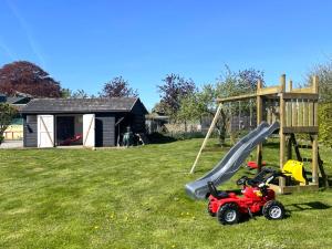 a playground with a slide and a toy tractor at Landhaus Markerup - großzügig mit Kamin, Sauna & Spielhaus in Husby +45 photos