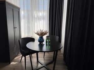 a dining room table with chairs and a vase on it at Apartament Centrum Chojniczanka in Chojnice