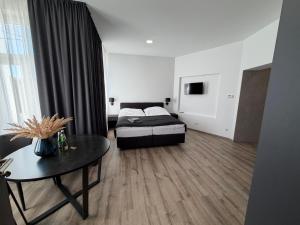 a bedroom with a bed and a table in it at Apartament Centrum Chojniczanka in Chojnice