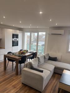 a living room with a couch and a table at T2 design climatisé au coeur de Divonne in Divonne-les-Bains