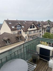 a balcony with a table and a view of buildings at T2 design climatisé au coeur de Divonne in Divonne-les-Bains