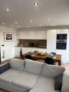 a living room with a couch and a kitchen at T2 design climatisé au coeur de Divonne in Divonne-les-Bains