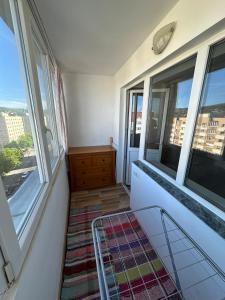 a room with a balcony with windows and a dresser at Perla Central Apartment in Zalău +5 photos