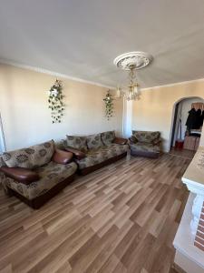 a living room with couches and a chandelier at Perla Central Apartment in Zalău