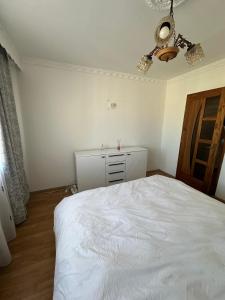 a bedroom with a white bed and a ceiling fan at Perla Central Apartment in Zalău