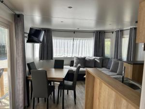 a living room and dining room with a couch and a table at Camping de Contrexeville in Contrexéville