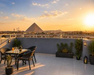 a rooftop patio with a table and pyramid in the background at phoenix Pyramids- roof top in Cairo
