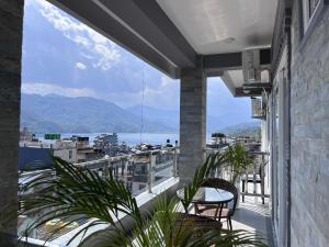 a balcony with two chairs and a view of the water at The Kagbeni Hotel in Pokhara