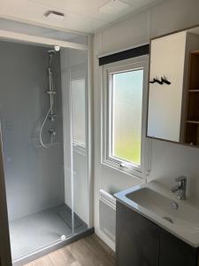 a bathroom with a shower and a sink and a window at Camping de Contrexeville in Contrexéville +62 photos