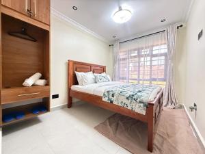 a bedroom with a bed and a window at Gono Retreat Four bedroom in Kisumu
