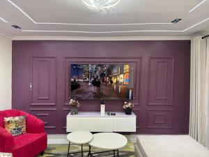 a living room with purple walls and a red couch at Gono Retreat Four bedroom in Kisumu