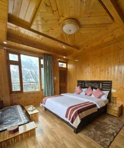 a bedroom with a large bed in a wooden room at The Sunflower Homes in Gondla