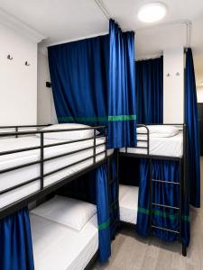 a room with three bunk beds with blue curtains at Smash Hostel Batumi in Batumi