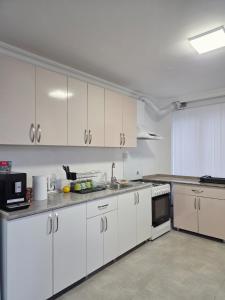 a kitchen with white cabinets and a counter top at Smash Hostel Batumi in Batumi +13 photos