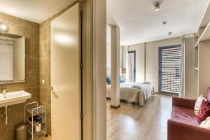 a bathroom with a sink and a bedroom with a bed at Aparthotel 1904 in Figueres +45 photos