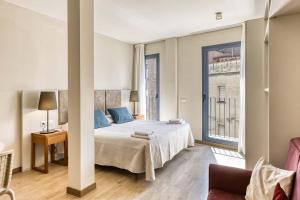 a bedroom with a bed and a large window at Aparthotel 1904 in Figueres