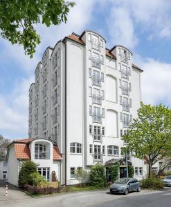 a white building with a car parked in front of it at smartments Hamburg Aussenalster in Hamburg
