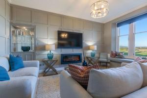 a living room with two couches and a fireplace at 20 Golf Place in St. Andrews