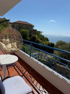 a balcony with a rattan umbrella and a table and chairs at Guesthouse Mili in Piqeras