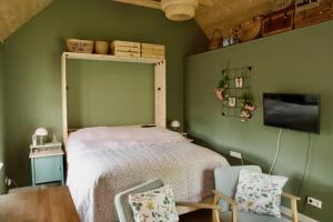 a bedroom with a bed with a mirror and a chair at Theetuin en B & B 'De Theetuin' in Wijckel
