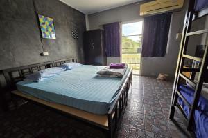 a bedroom with a bed with a blue comforter at Malai Place Lampang in Lampang