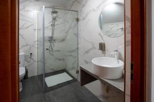 a bathroom with a sink and a glass shower at Pensiune Cabana Bradet in Şimleu Silvaniei