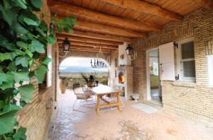 a patio with a table and chairs on a brick wall at Guesthouses Thomas & Cato in Vátos