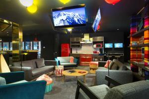 a living room with couches and a flat screen tv at RockyPop Chamonix - Les Houches in Les Houches
