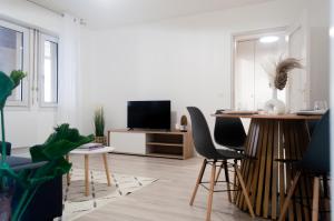 a living room with a table and chairs and a tv at The Graoully's Cave - Hyper Centre in Metz
