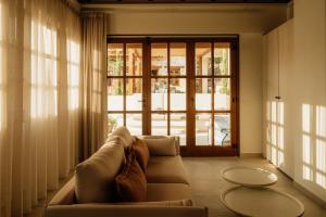 a living room with a couch and a large window at Galetso Studios by Still Collection in Nikiti +24 photos