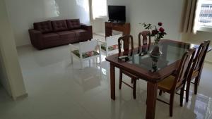 uma sala de estar com uma mesa de vidro e um sofá em F&F INN a 50 mts da Praia de Ponta Verde em Maceió