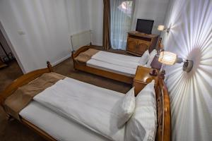 a bedroom with two beds and a desk with a television at Pensiune Cabana Bradet in Şimleu Silvaniei