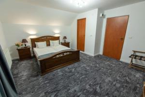 a bedroom with a large wooden bed and a door at Pensiune Cabana Bradet in Şimleu Silvaniei
