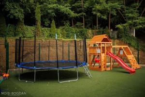 a playground with a slide and a play house at Pensiune Cabana Bradet in Şimleu Silvaniei