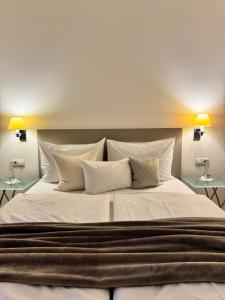 a large bed with white sheets and pillows at Plaza Rooms & Studios in Forchheim