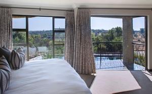 a bedroom with a bed and a large window at The Blades in Pretoria